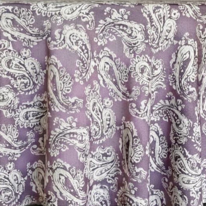 Eclectic round tablecloth in dusty plum with a white paisley pattern and a textured linen-look finish.