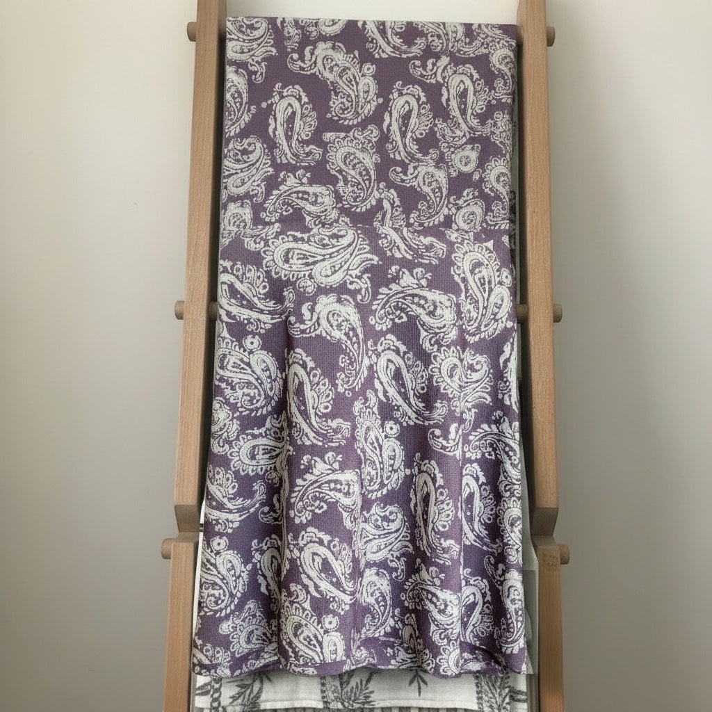 Eclectic dusty plum round tablecloth with a white paisley pattern and a soft linen-look texture draped over a ladder.