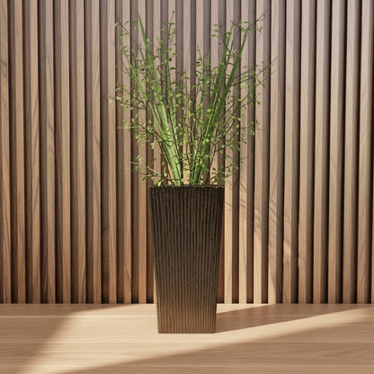 Eclectic earth brown ceramic floor vase with vertical ribbed texture holding tall green stems against a wood slat wall