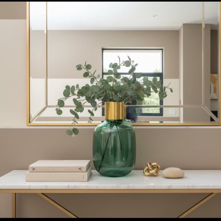 Eclectic emerald green textured glass vase with a brushed brass collar, styled with eucalyptus on a marble console table.