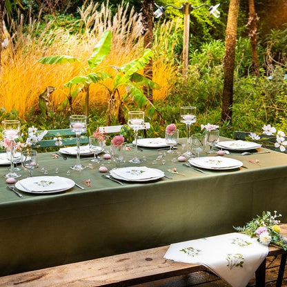 Eclectic Fleurs des Prés cocktail napkins with wildflower print on a garden table setting with green tablecloth
