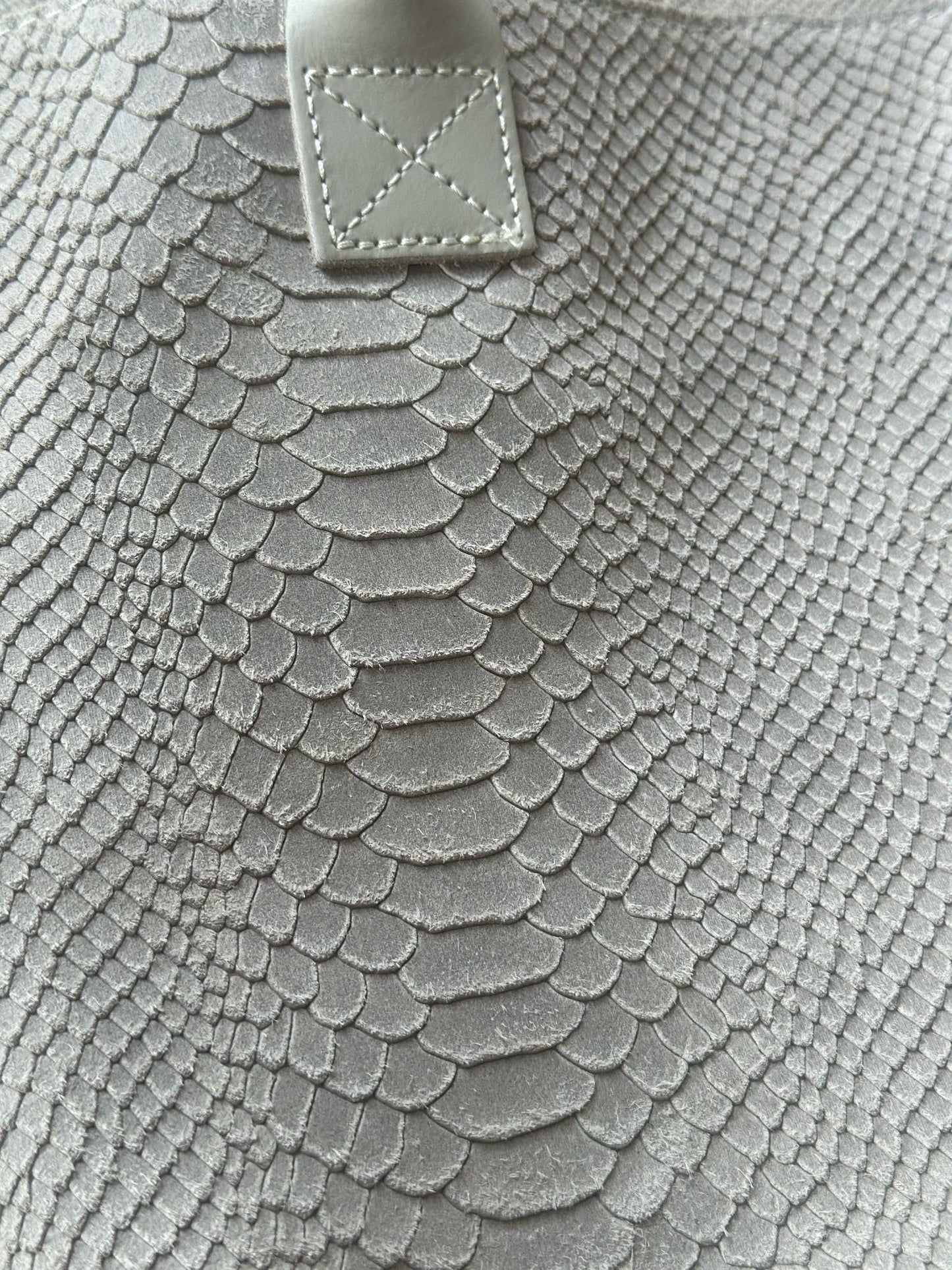 Close-up of Eclectic Florenza cream suede shopper bag featuring a detailed snake-print texture and stitched handle.
