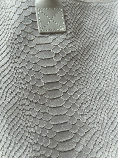 Close-up of Eclectic Florenza cream suede shopper bag featuring a detailed snake-print texture and stitched handle.