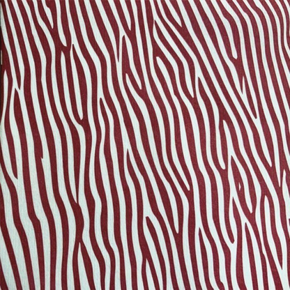 Eclectic Françoise Paviot Dune Terre airlaid dinner napkin featuring a deep red and white abstract zebra stripe pattern.