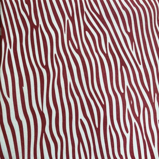 Eclectic Françoise Paviot Dune Terre airlaid dinner napkin featuring a deep red and white abstract zebra stripe pattern.