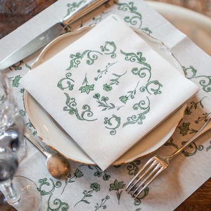 Eclectic Françoise Paviot Régence Vert airlaid dinner napkin with green botanical motifs on a white plate setting.