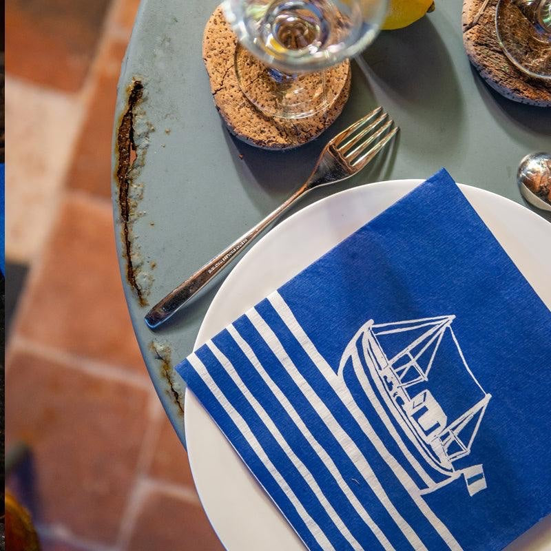 Eclectic Françoise Paviot Chalutier marine blue airlaid dinner napkin with a fishing boat print on a table setting