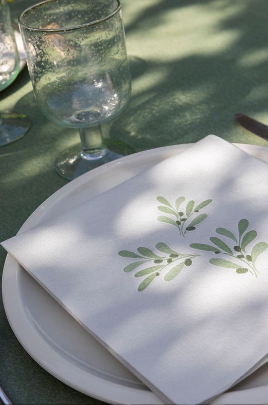 Eclectic Françoise Paviot Olivier dinner napkin with green olive branch print on a white plate on a green table