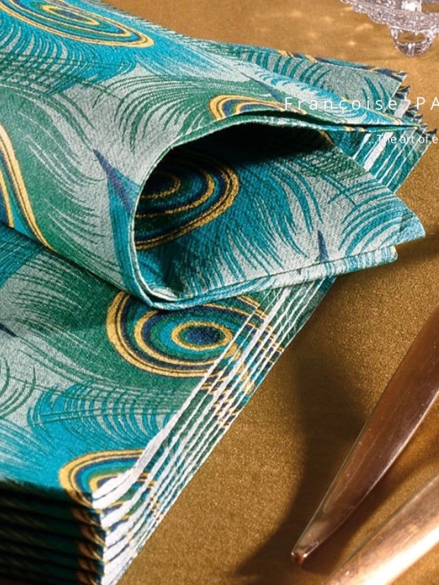 Eclectic Françoise Paviot Paon dinner napkins featuring an emerald, teal, and gold peacock feather print on airlaid paper.