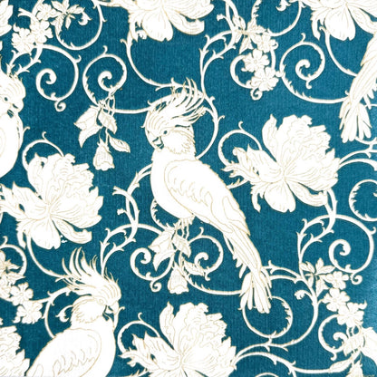 Eclectic Françoise Paviot dinner napkin featuring ivory parakeets and floral arabesques on a deep petrol blue background