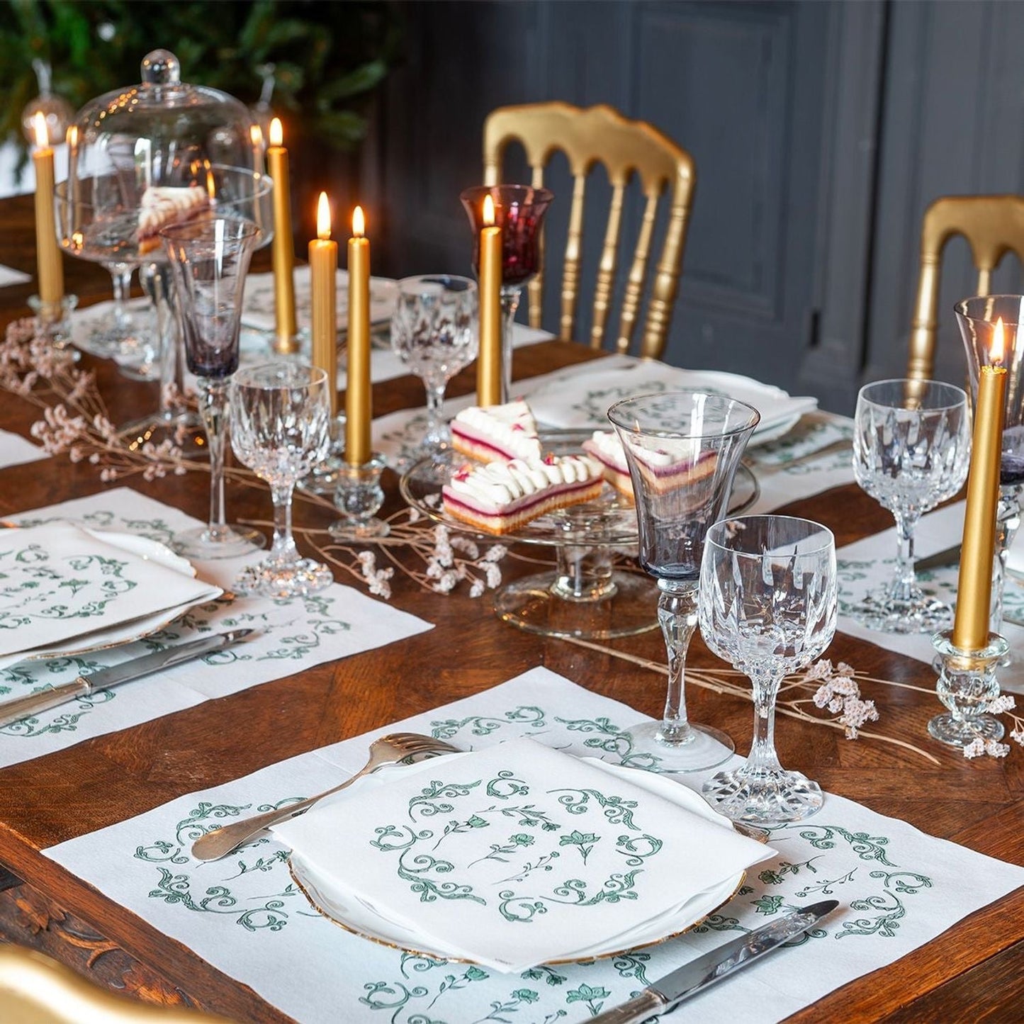 Eclectic Françoise Paviot Régence Vert airlaid dinner napkins with green ornamental motifs on a formal dining table.