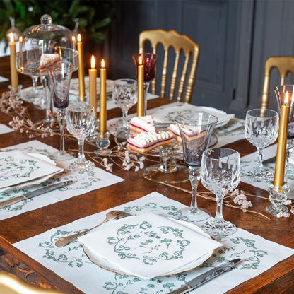 Eclectic Françoise Paviot Régence Vert airlaid dinner napkins with green ornamental motifs on a formal dining table.