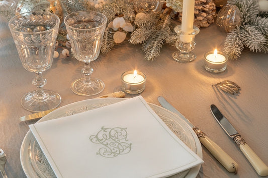 Eclectic Françoise Paviot Chiffre Argent silver monogram airlaid dinner napkin on a festive holiday table setting.