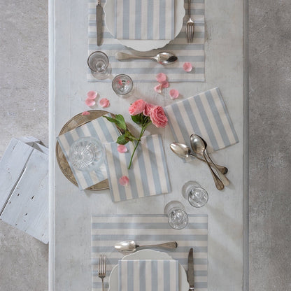 Eclectic Françoise Paviot blue-grey striped airlaid dinner napkins set on a rustic white table with floral decor.