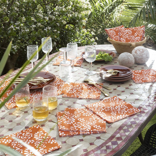 Eclectic Françoise Paviot Arabesque Terra dinner napkins with white floral patterns on a terracotta airlaid fabric.