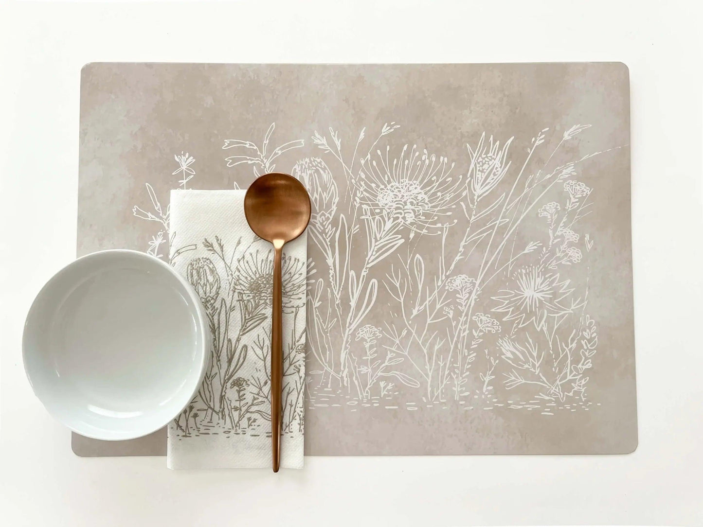 Eclectic Fynbos Oatmeal reusable placemat with white botanical line art, satin finish, and wipe-clean paperboard.