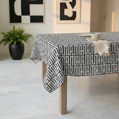 Eclectic black and white geometric linen-look tablecloth on a wooden dining table in a modern room.