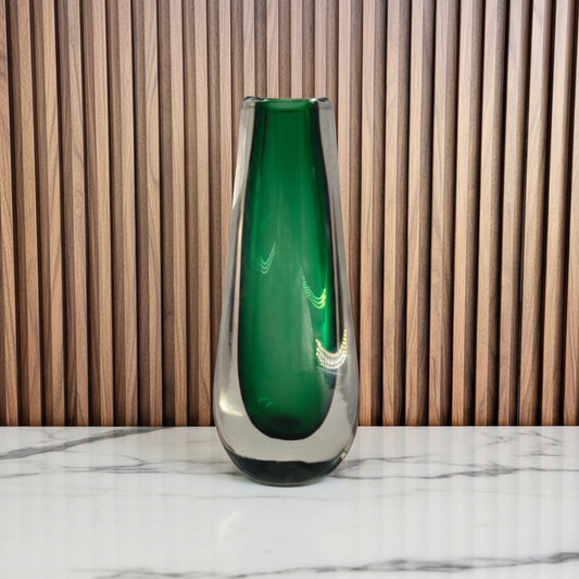 Eclectic green drop art glass vase with a smooth polished finish and clear glass casing on a marble surface.