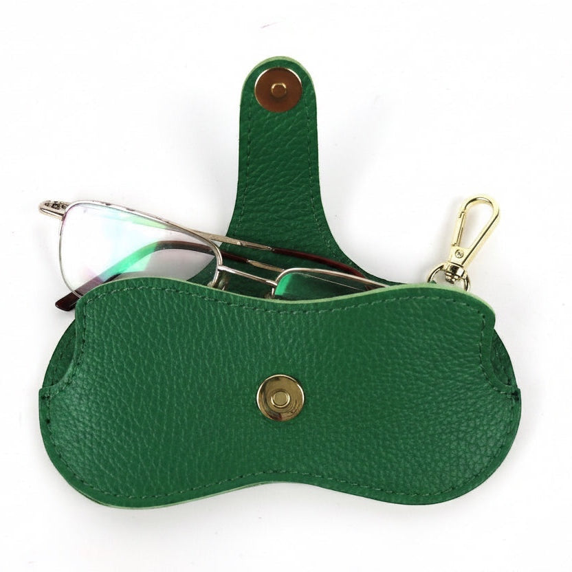 Eclectic green leather glasses case with gold-tone snap button and clip, shown open with eyewear inside.