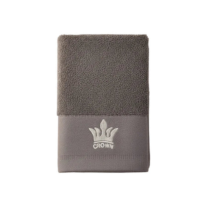 Eclectic grey cotton guest towel featuring an elegant embroidered crown detail and soft absorbent texture.