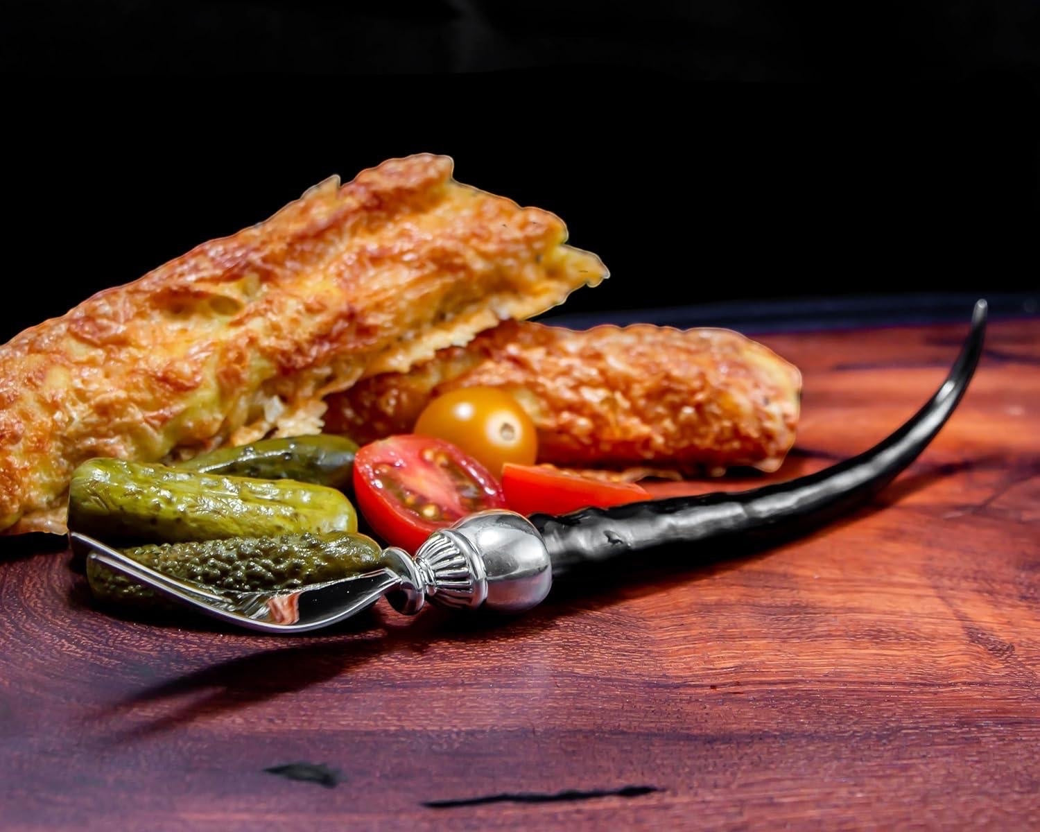 Eclectic Impondo Zulu pickle fork with ebony resin handle and pewter detail on a wooden board with appetizers.