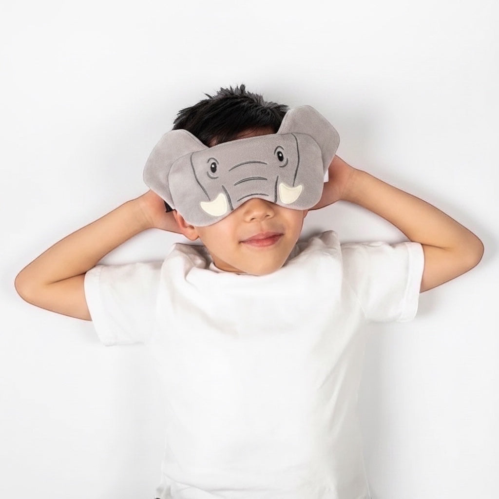 Child wearing a grey Janu the Elephant eye mask from the Eclectic Relaxeazzz travel pillow set