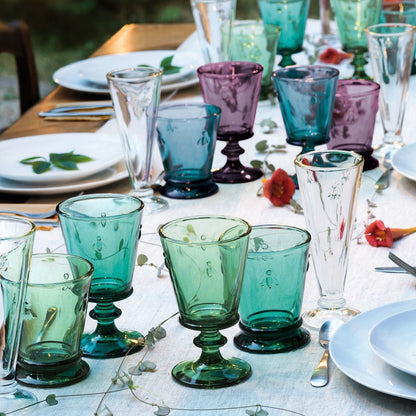 Eclectic La Rochère Abeille French Bee tumblers in assorted jewel tones arranged on a dining table.
