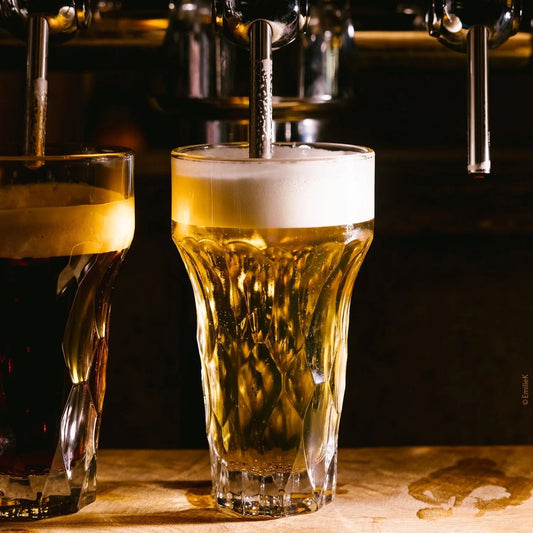 Eclectic La Rochère Silex clear pressed glass beer glasses with textured flint-inspired design under a beer tap