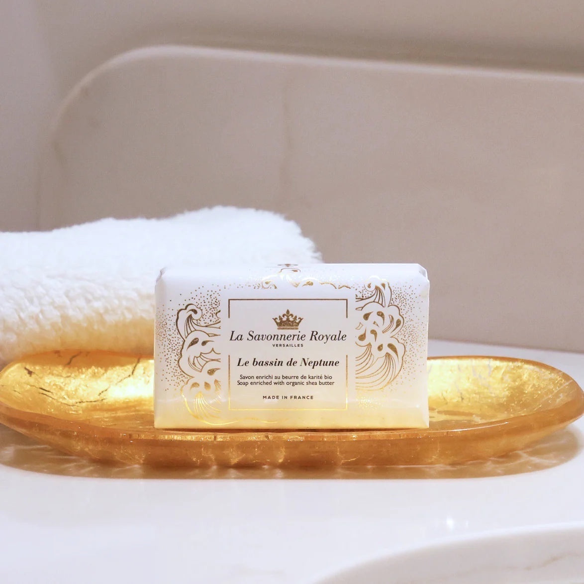 Eclectic La Savonnerie Royale Le Bassin de Neptune ivory soap bar with fleur-de-lys detail on a gold dish