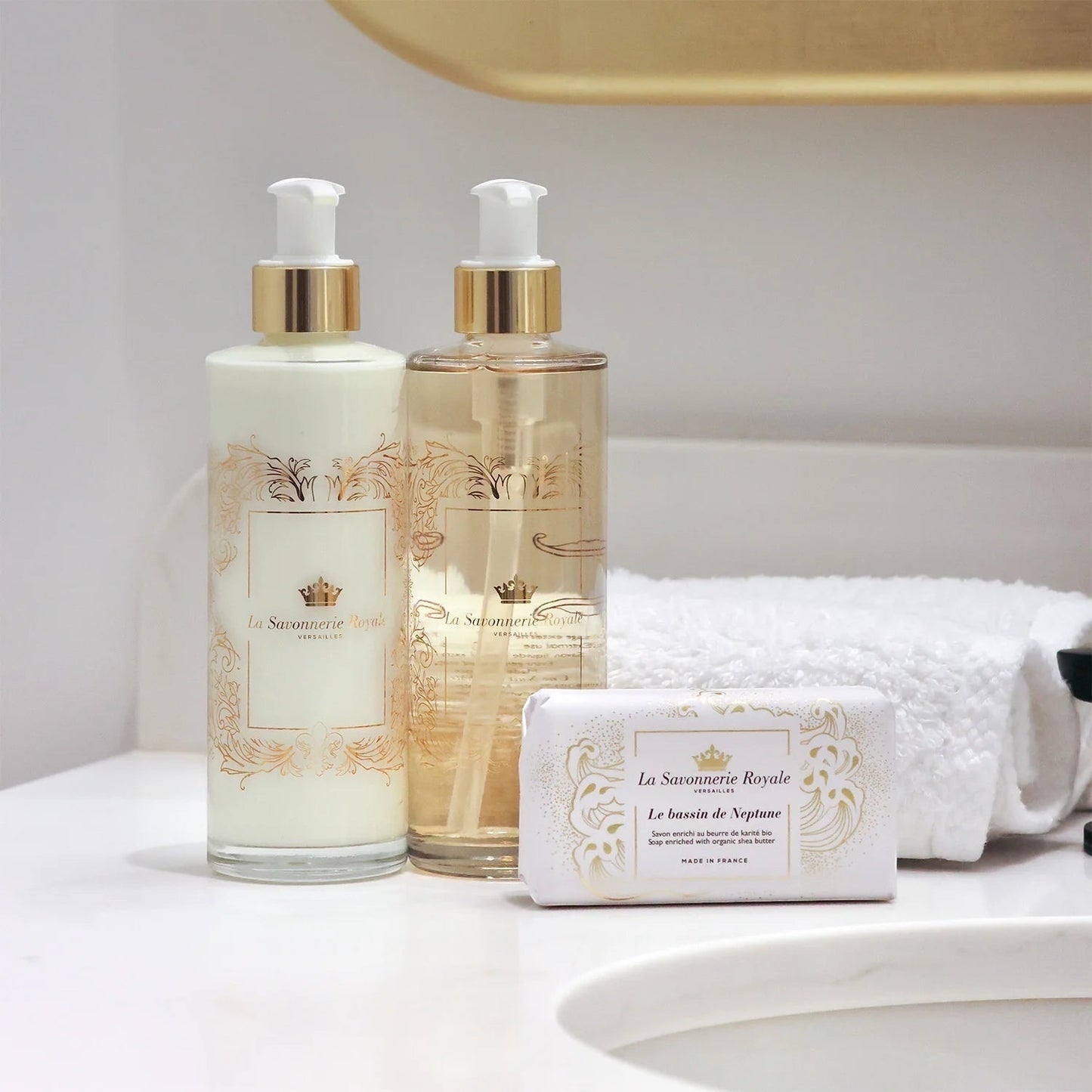 Eclectic La Savonnerie Royale Le Bassin de Neptune soap bar and matching lotion bottles on a white bathroom counter