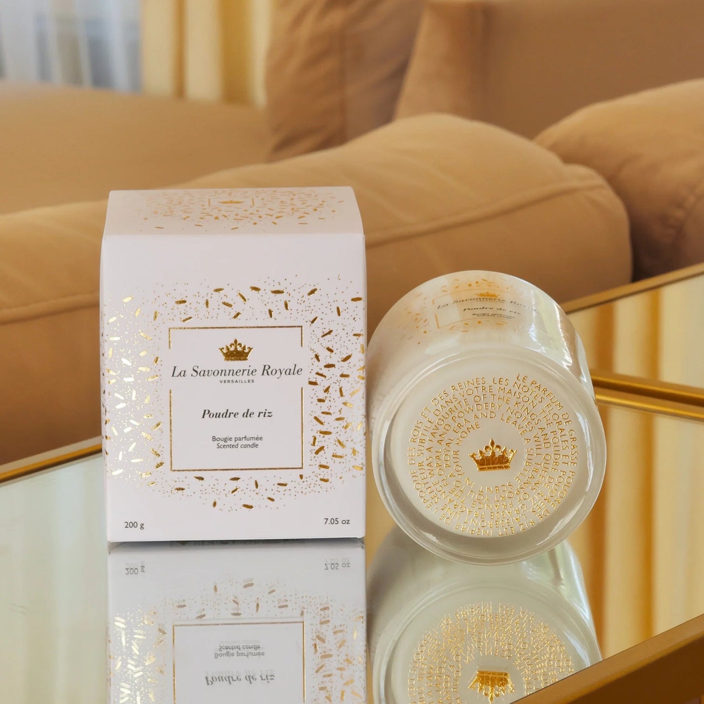 Eclectic La Savonnerie Royale Poudre de Riz candle and white box with gold foil accents on a reflective surface.