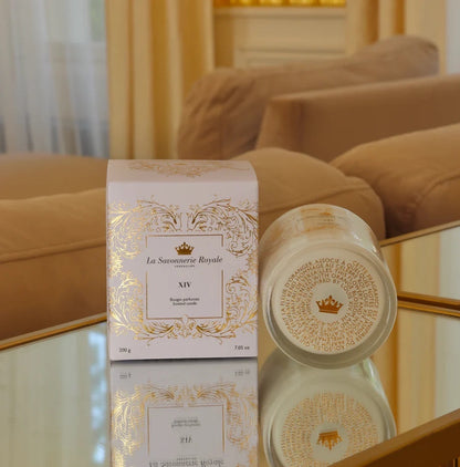 Eclectic La Savonnerie Royale XIV candle in a decorative glass vessel with matching white and gold box on a mirror.