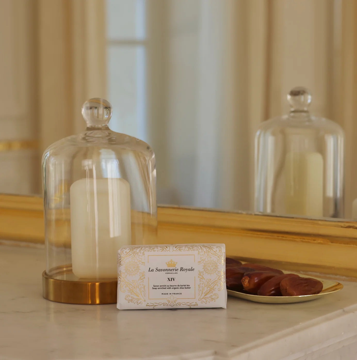 Eclectic La Savonnerie Royale XIV soap bar in ivory packaging with gold Fleur-de-lys detail on a marble surface.