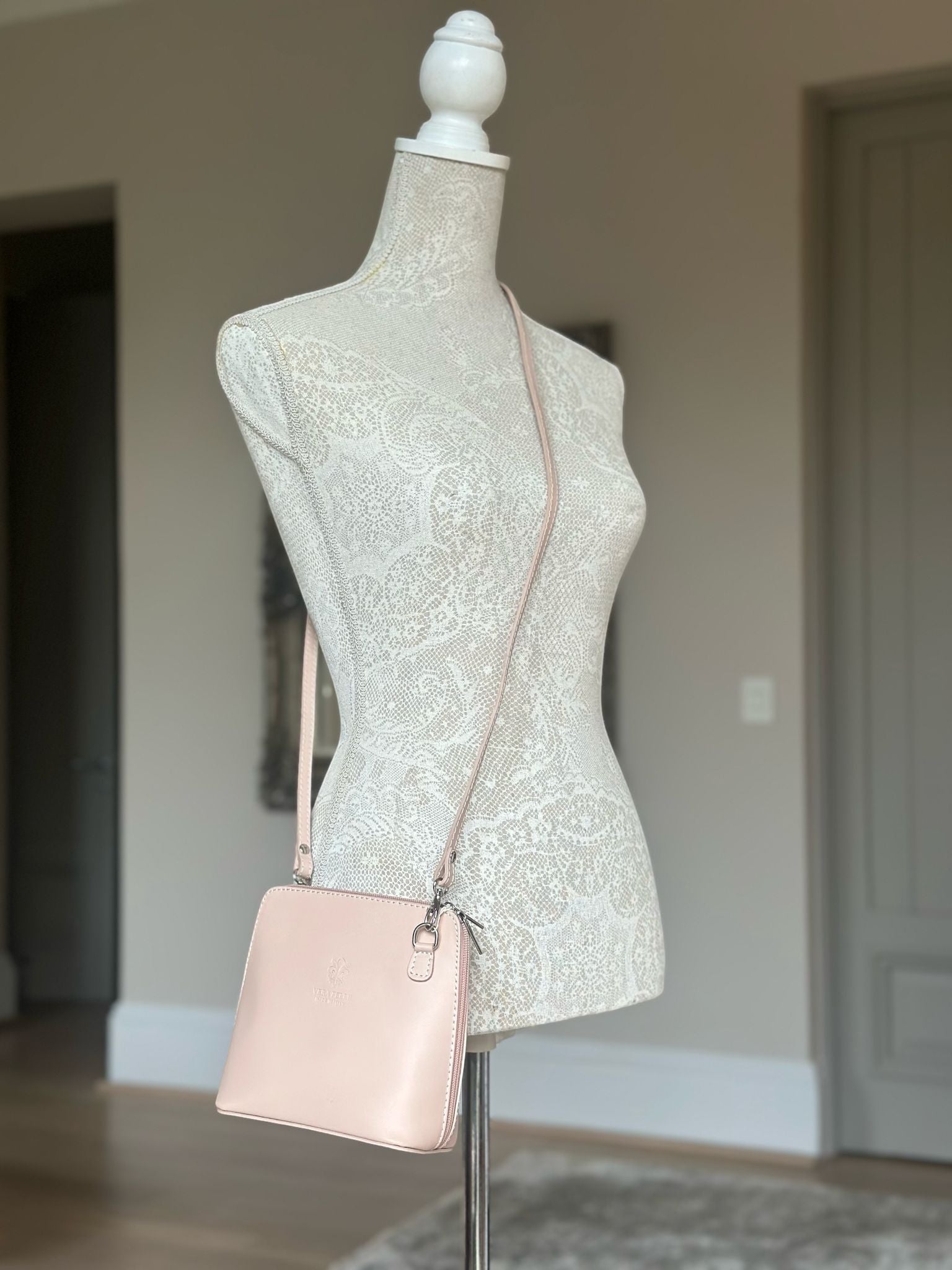 Eclectic Mini Milano crossbody bag in soft pink smooth leather with silver hardware displayed on a lace mannequin
