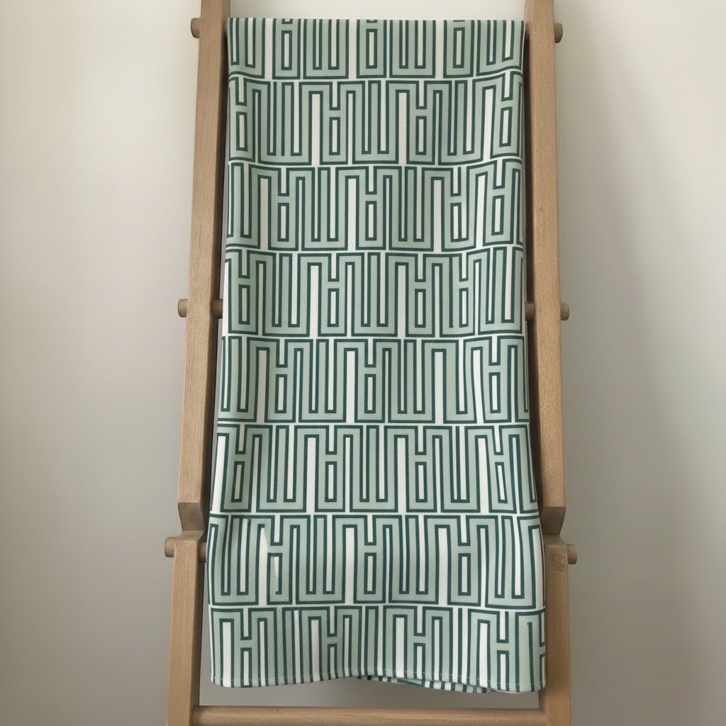 Eclectic mint green linen-look tablecloth featuring a modern geometric pattern draped over a wooden ladder.