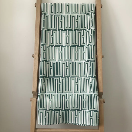 Eclectic mint green linen-look tablecloth featuring a modern geometric pattern draped over a wooden ladder.