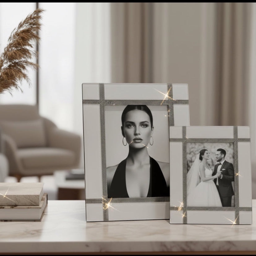 Eclectic mirrored photo frames with crystal grid detailing displayed on a marble tabletop in a modern living room.