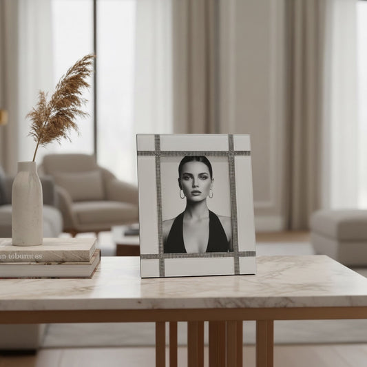 Eclectic mirrored photo frame with crystal grid detailing displayed on a marble table in a modern living room.