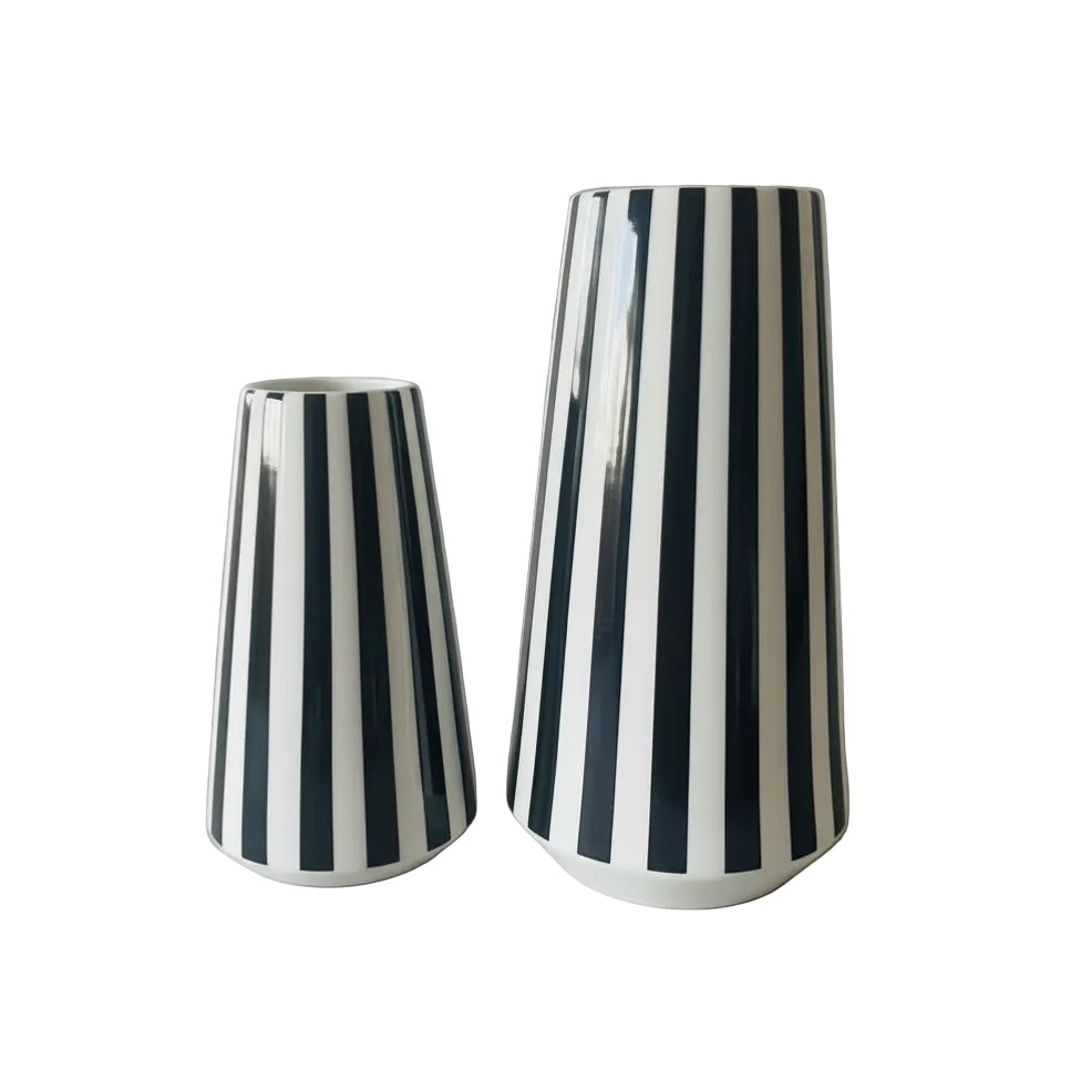 Eclectic set of two glossy ceramic vases with bold black and white vertical stripes and modern tapered silhouettes.