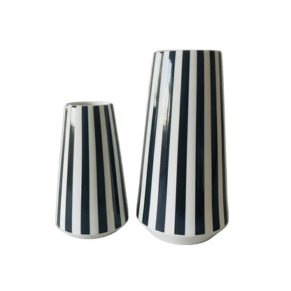 Eclectic set of two glossy ceramic vases with bold black and white vertical stripes and modern tapered silhouettes.