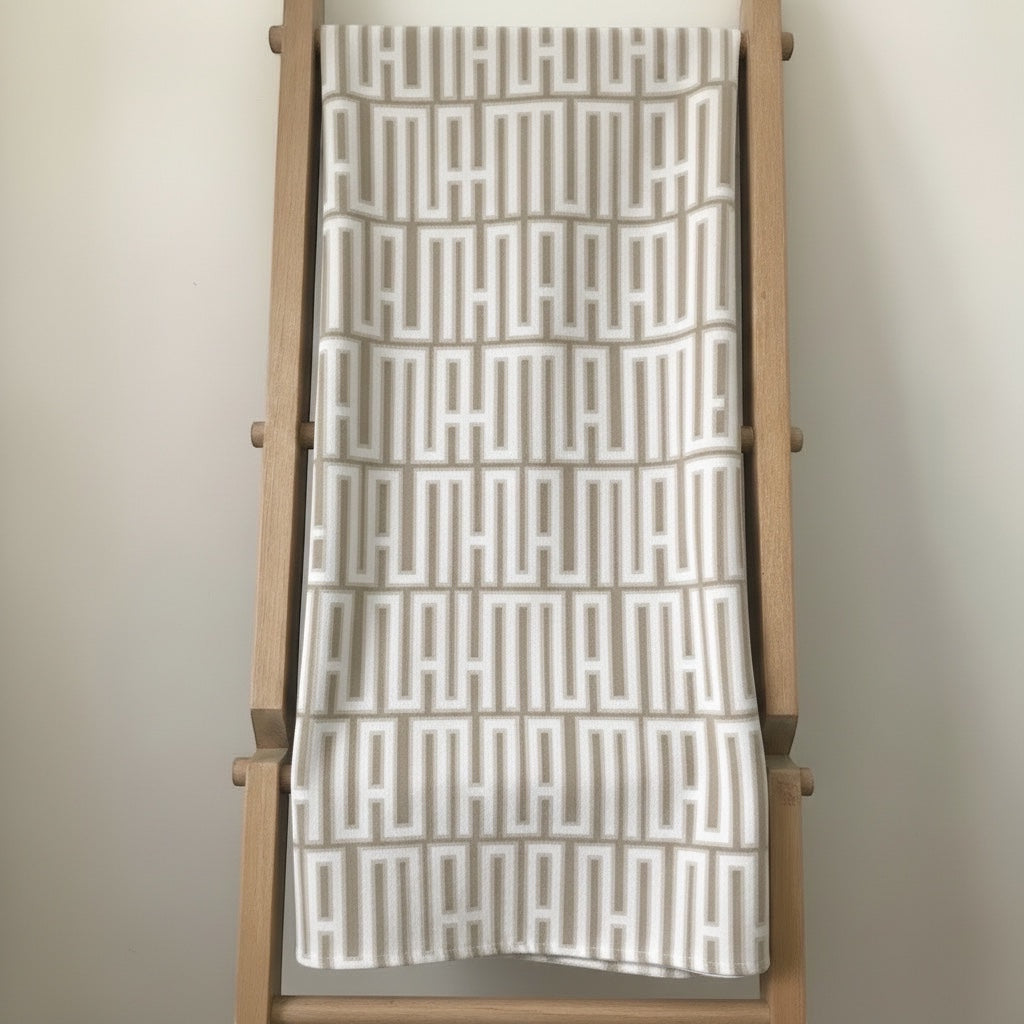 Eclectic natural linen-look tablecloth featuring a white and beige geometric pattern draped over a wooden ladder.