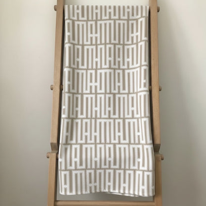 Eclectic natural linen-look tablecloth featuring a white and beige geometric pattern draped over a wooden ladder.