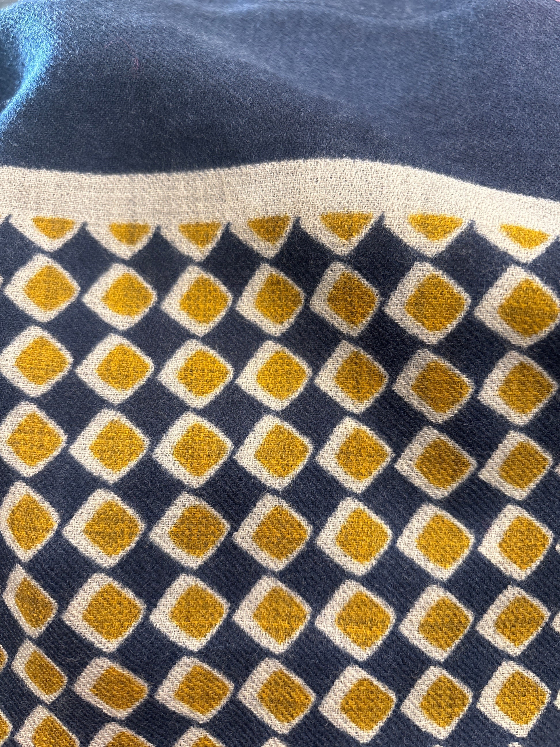 Eclectic navy and gold cashmere wool blend scarf featuring a geometric diamond pattern in a soft lightweight weave.