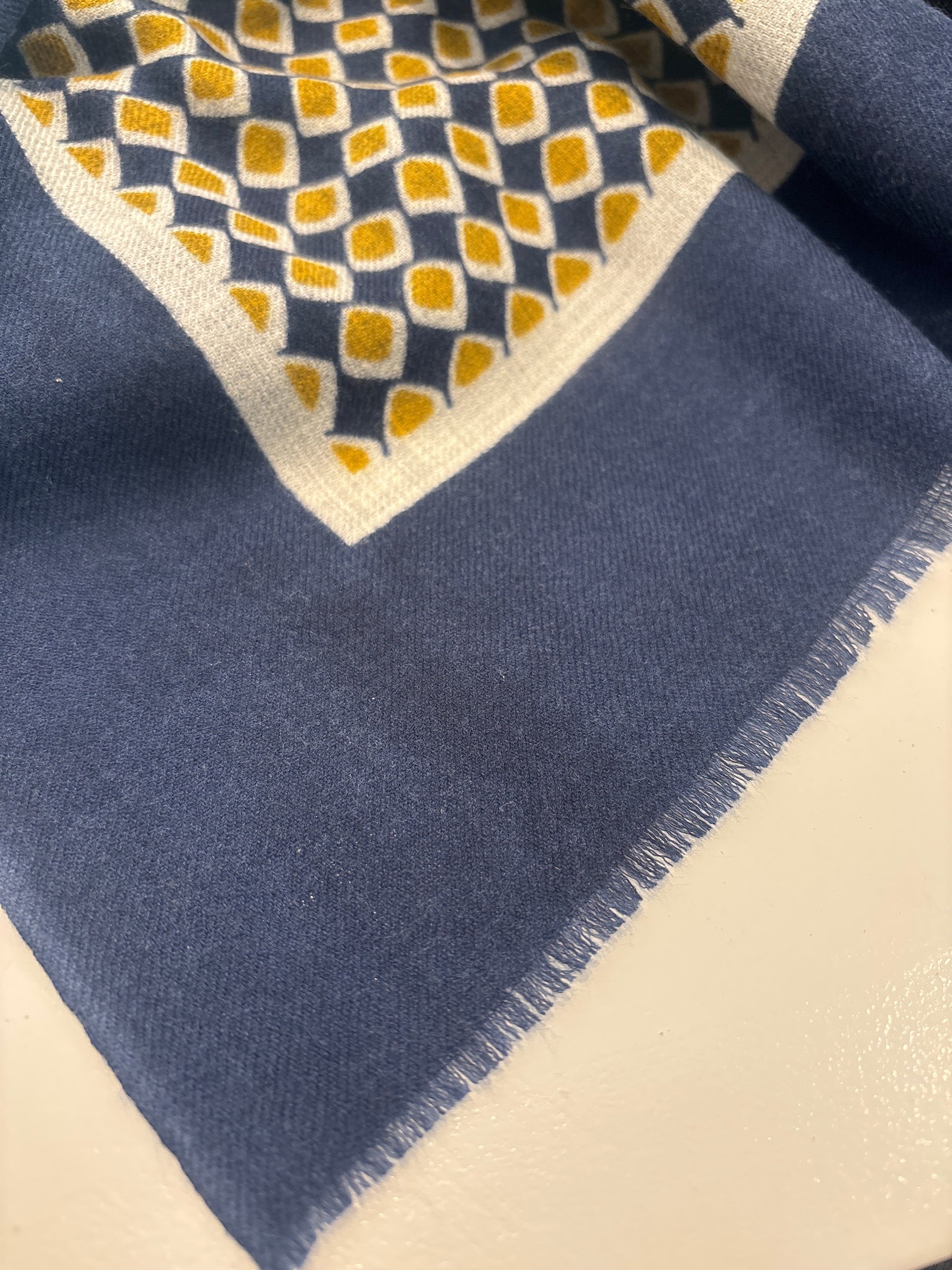 Eclectic navy and gold cashmere blend scarf with a geometric diamond pattern and delicate frayed edge detail.