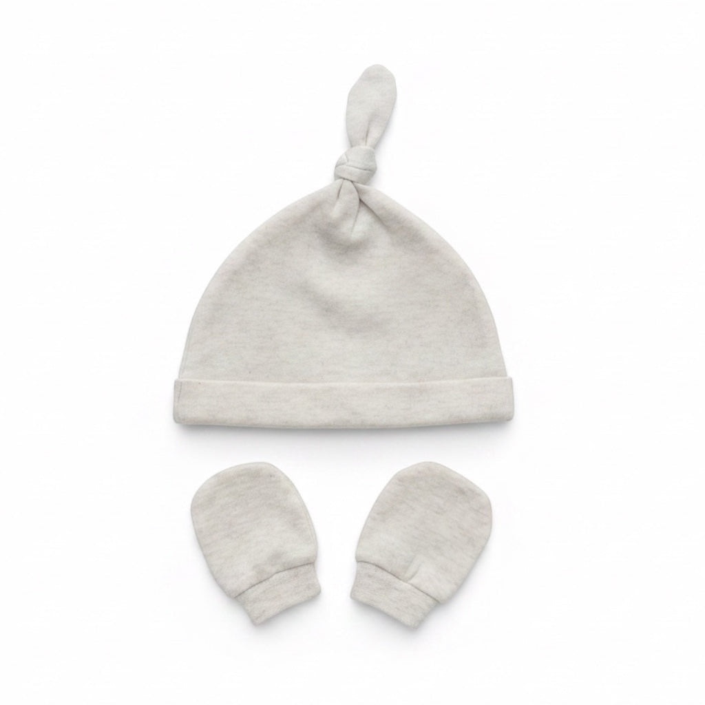 Eclectic newborn knotted hat and matching mittens set in soft neutral cotton for baby comfort and scratch protection.