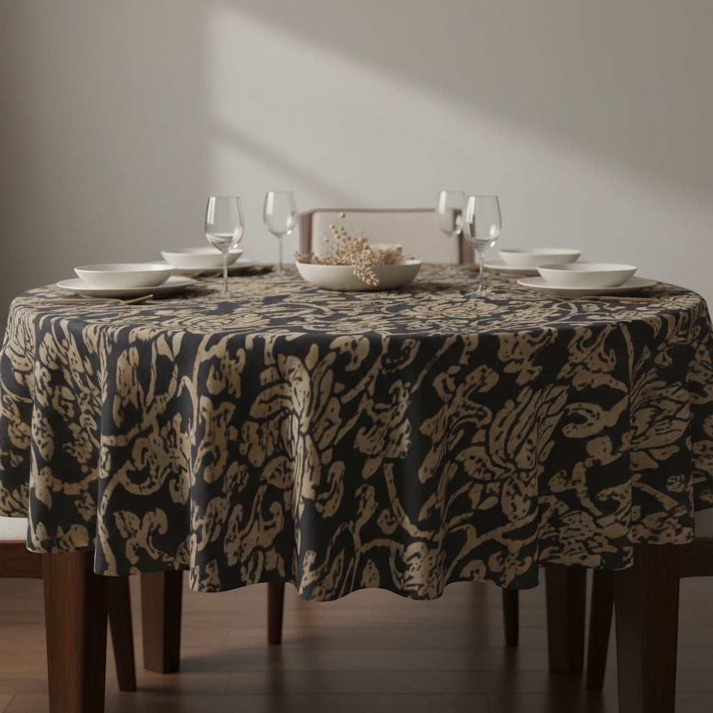 Eclectic Noir Baroque round tablecloth in black and gold featuring an intricate pattern on a dining table setting.