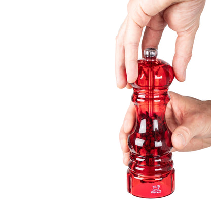Eclectic Peugeot Podium red acrylic salt and pepper mill being held and adjusted by hand