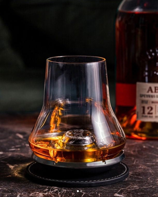 Eclectic Peugeot whisky tasting glass with domed base and chilling stand on a leather coaster with amber spirit