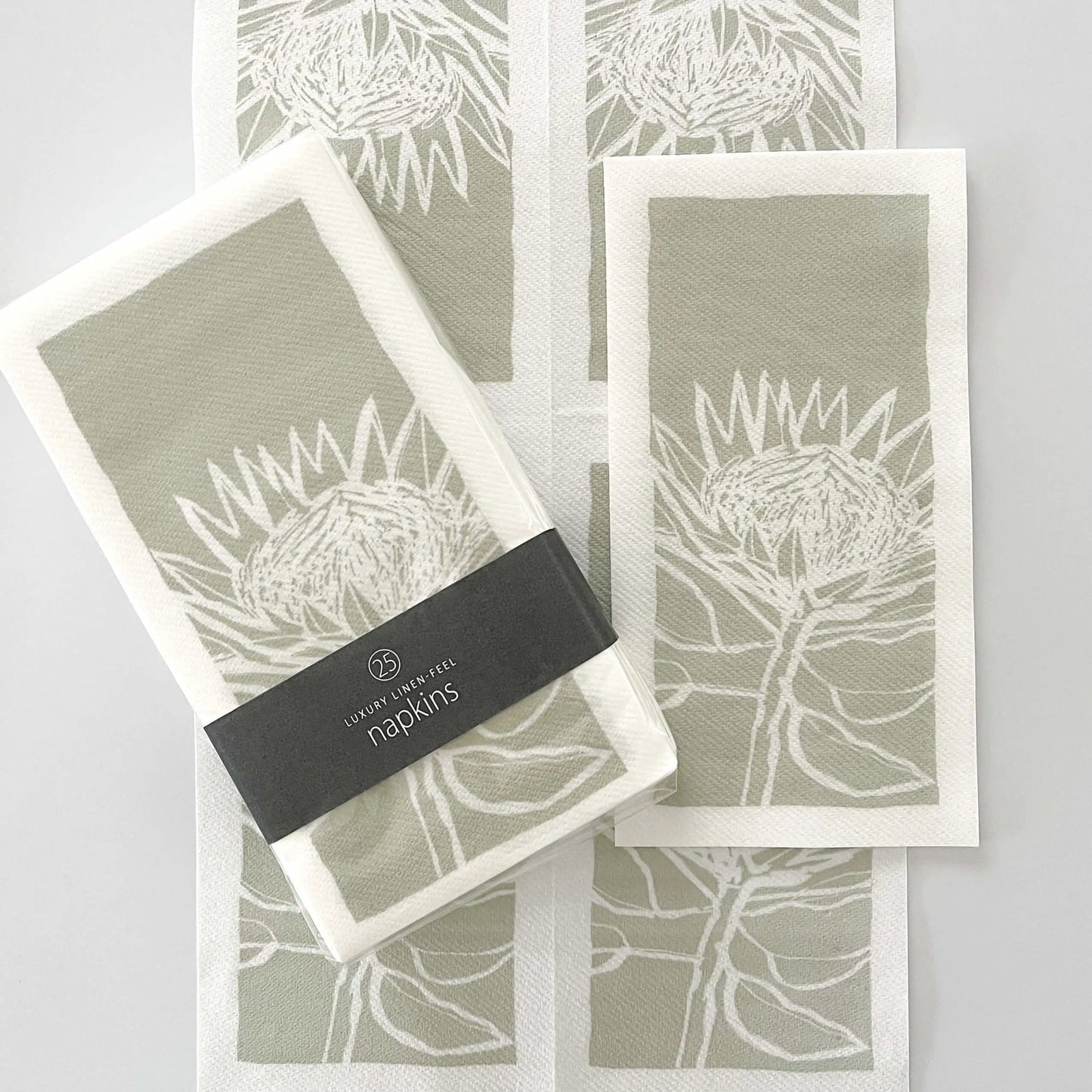 Eclectic Protea Green disposable airlaid napkins with a linen-like texture and botanical protea flower print.