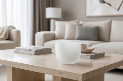 Eclectic Quartz rounded frosted white glass vase on a modern wooden coffee table in a minimalist living room.